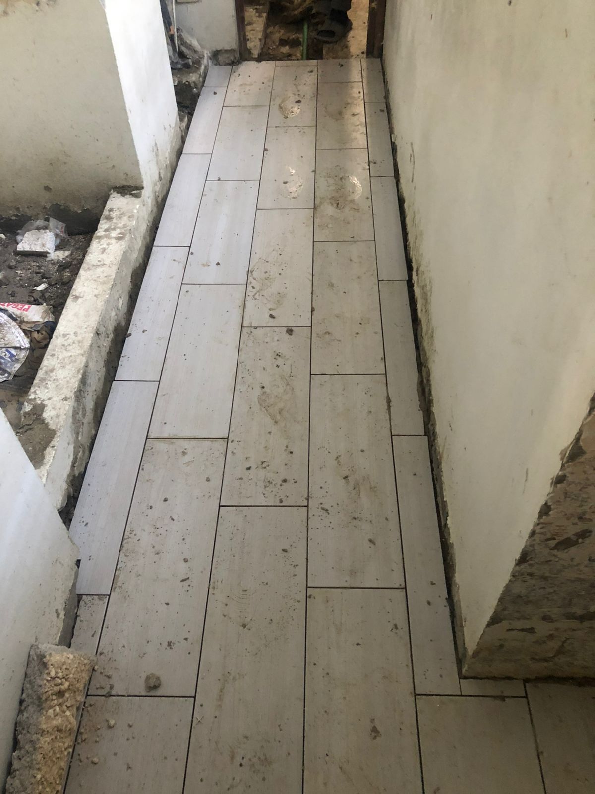 Colocación de piso durante el remozamiento de baños en la ENJ