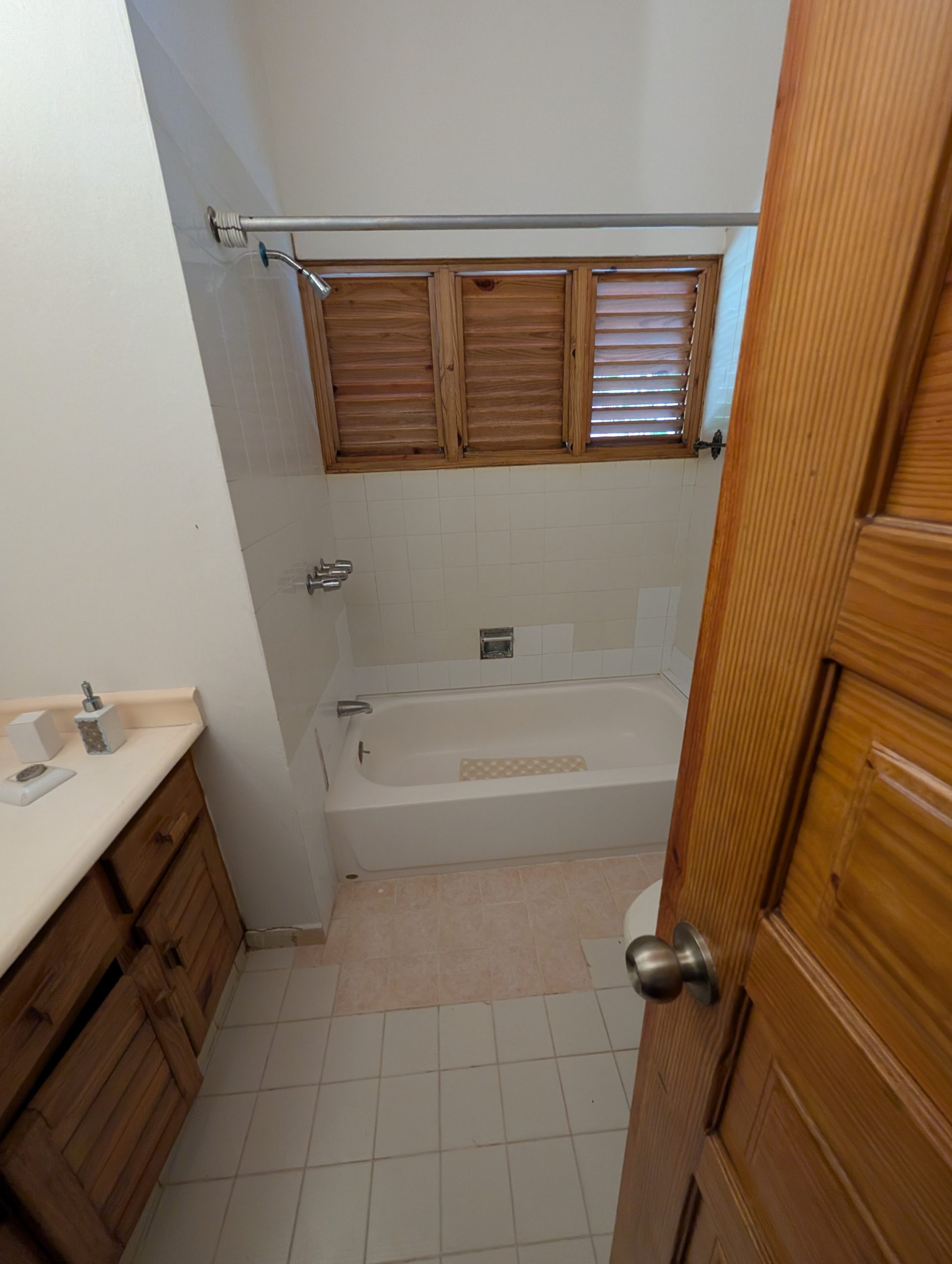 Baño de la villa con bañera y piso de cerámica antes de la remodelación
