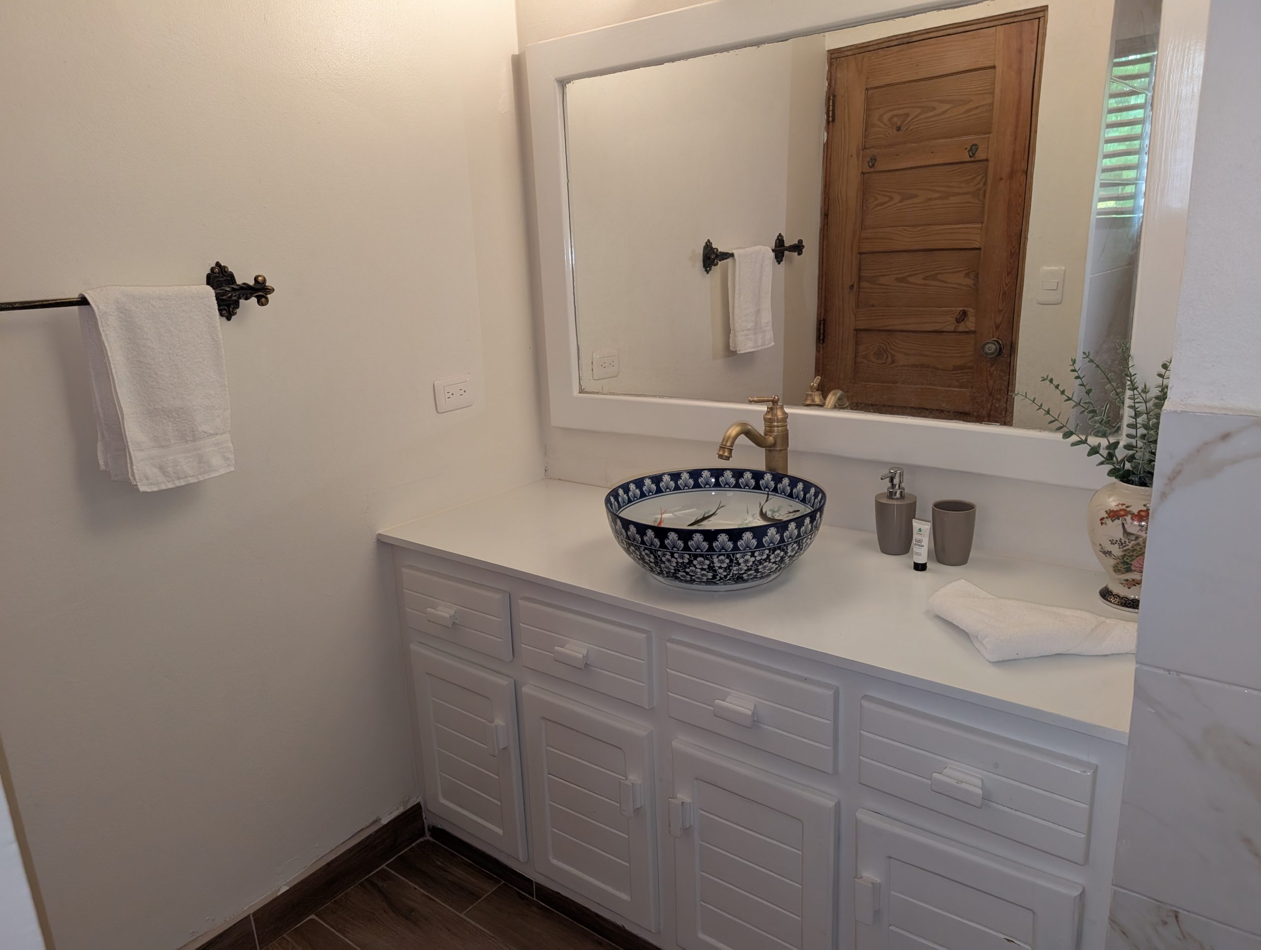 Baño remodelado con lavamanos sobre encimera y espejo