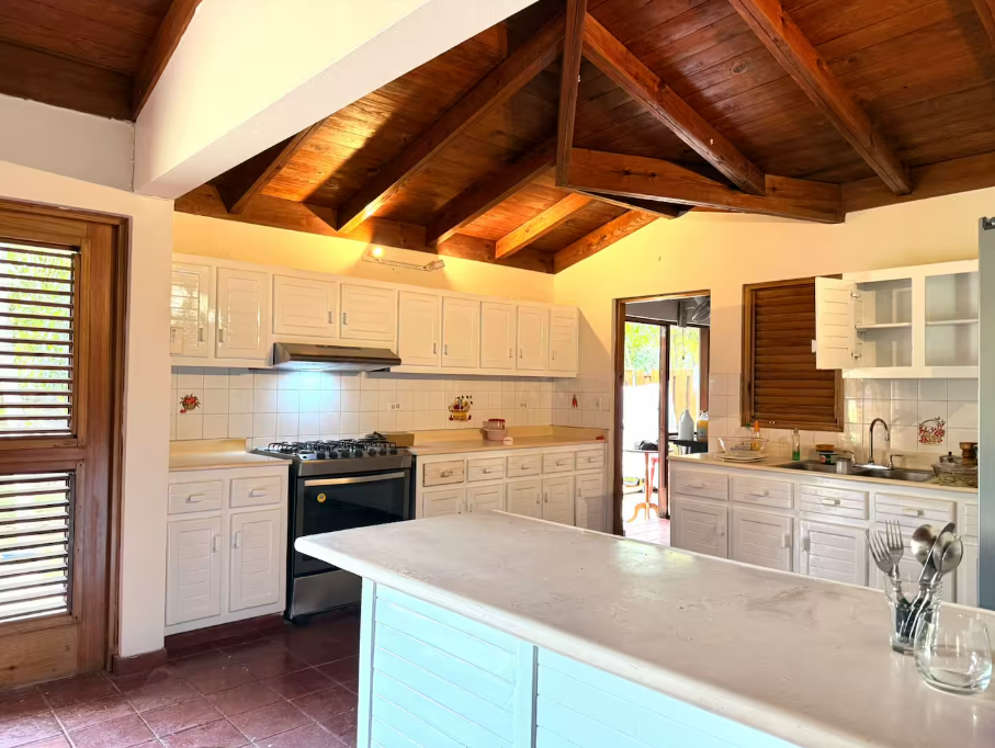 Cocina de la villa terminada, con gabinetes blancos y una isla central
